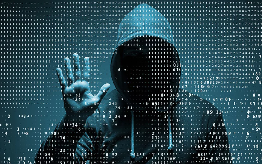 A hooded figure against a backdrop of binary code, symbolizing cybersecurity and hacking.